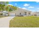 Well-kept home features a spacious lawn, wide driveway, and welcoming entryway with plenty of natural light at 3860 Whiting Se Dr, St Petersburg, FL 33705