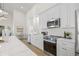 Modern kitchen featuring stainless steel appliances, white cabinets, and quartz countertops with open floor plan at 3860 Whiting Se Dr, St Petersburg, FL 33705