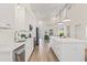 Bright, open kitchen featuring white cabinets, stainless appliances, quartz countertops and a large island at 3860 Whiting Se Dr, St Petersburg, FL 33705