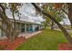 Charming backyard patio with blue chairs nestled under mature, blossoming trees at 401 Dorchester Pl # 69, Sun City Center, FL 33573