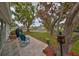 Backyard patio has blue chairs, mature trees, and a lush lawn at 401 Dorchester Pl # 69, Sun City Center, FL 33573