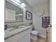 Bright bathroom features a granite countertop, white vanity, and decorative mirror at 401 Dorchester Pl # 69, Sun City Center, FL 33573