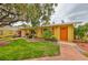 Charming yellow home with an orange door, lush green lawn, and mature landscaping at 401 Dorchester Pl # 69, Sun City Center, FL 33573