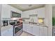 Bright kitchen featuring stainless steel appliances, white cabinets and granite countertops at 401 Dorchester Pl # 69, Sun City Center, FL 33573
