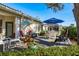 Backyard deck with patio furniture, shade umbrella, and verdant landscaping at 412 Pinewood Dr, Oldsmar, FL 34677