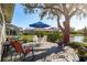 Backyard deck with patio furniture, a blue umbrella, and lush landscaping at 412 Pinewood Dr, Oldsmar, FL 34677