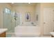 Bright bathroom features a tiled soaking tub, separate glass shower, and ample lighting at 412 Pinewood Dr, Oldsmar, FL 34677