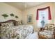 Charming bedroom features a ceiling fan, floral bedding, and window at 412 Pinewood Dr, Oldsmar, FL 34677