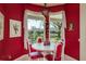 Cozy dining area with red accent wall, table, and window overlooking the lake at 412 Pinewood Dr, Oldsmar, FL 34677