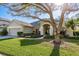 Charming single-story home with a well-manicured lawn, mature tree, and inviting front entrance at 412 Pinewood Dr, Oldsmar, FL 34677