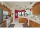 Bright kitchen featuring wood cabinets, a breakfast bar, and stainless steel appliances for modern convenience at 412 Pinewood Dr, Oldsmar, FL 34677