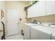 Functional laundry room with cabinets, appliances and tile floors for easy cleaning at 412 Pinewood Dr, Oldsmar, FL 34677