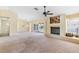 Open-concept living room with a fireplace, carpet and bright light from an open doorway at 4486 Gaston St, Spring Hill, FL 34607