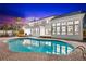 Night view of backyard featuring in-ground pool reflecting lights from the two-story home at 517 Belle Isle Ave, Belleair Beach, FL 33786