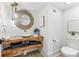 Stylish powder room with unique wood countertop, vessel sink, designer mirror, and modern fixtures at 517 Belle Isle Ave, Belleair Beach, FL 33786