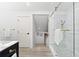 Bathroom features a glass door shower, modern vanity and wood flooring at 517 Belle Isle Ave, Belleair Beach, FL 33786