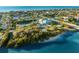 Aerial view showcasing a community building, tennis courts, and lush landscaping near the waterfront at 517 Belle Isle Ave, Belleair Beach, FL 33786