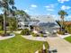 Stunning two-story home featuring a metal roof, lush landscaping, and a well-manicured lawn at 517 Belle Isle Ave, Belleair Beach, FL 33786