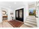 Inviting foyer featuring custom iron doors, wood floors, and a staircase, complemented by stylish decor at 517 Belle Isle Ave, Belleair Beach, FL 33786