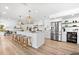 Modern kitchen with a large island, stainless steel appliances, and stylish pendant lighting at 517 Belle Isle Ave, Belleair Beach, FL 33786