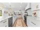 Open-concept kitchen boasts white cabinets, marble countertops, and stainless steel appliances at 517 Belle Isle Ave, Belleair Beach, FL 33786