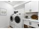 Clean laundry room with modern washer and dryer, and white storage cabinets at 517 Belle Isle Ave, Belleair Beach, FL 33786