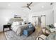 Spacious primary bedroom with ceiling fan, accent chairs and sliding barn door at 517 Belle Isle Ave, Belleair Beach, FL 33786