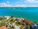 Waterfront property with manicured grounds and mature trees, offering amazing views of the bay and distant cityscape at 520 Belle Isle Ave, Belleair Beach, FL 33786