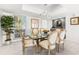 Dining room featuring a modern light fixture, glass table, seating for six, and bright windows at 520 Belle Isle Ave, Belleair Beach, FL 33786