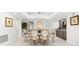 Dining room with modern light fixture, seating for six, and sleek tiled floors at 520 Belle Isle Ave, Belleair Beach, FL 33786