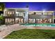Elegant waterfront home featuring a private pool, spiral staircase, and well-lit interiors at night at 520 Belle Isle Ave, Belleair Beach, FL 33786