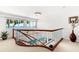 Stairway with glass railing, views of waterfront, and a decorative chandelier creates an inviting entryway at 520 Belle Isle Ave, Belleair Beach, FL 33786