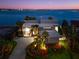 Elegant estate with meticulous landscaping and ambient lighting that create an inviting ambiance with views of the bay at 520 Belle Isle Ave, Belleair Beach, FL 33786