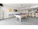 Basement recreation room area featuring a pool table, bar, and comfortable seating on neutral colored carpet at 520 Belle Isle Ave, Belleair Beach, FL 33786