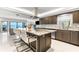 Spacious kitchen with a large granite island and modern dark wood cabinets with stainless steel appliances, bay view beyond at 520 Belle Isle Ave, Belleair Beach, FL 33786