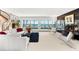 Elegant living room featuring a curved staircase, expansive windows with waterfront views, and modern decor at 520 Belle Isle Ave, Belleair Beach, FL 33786