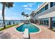 Relaxing pool area with bay view, perfect for enjoying the Florida lifestyle, and outdoor spiral staircase at 520 Belle Isle Ave, Belleair Beach, FL 33786
