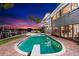 Stunning backyard pool with a diving board, set against the backdrop of a luxurious waterfront home at dusk at 520 Belle Isle Ave, Belleair Beach, FL 33786