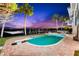 Inviting backyard pool with a diving board, surrounded by lush landscaping and a waterfront view at dusk at 520 Belle Isle Ave, Belleair Beach, FL 33786