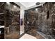 Luxurious black marble shower with a built-in bench and modern fixtures at 520 Belle Isle Ave, Belleair Beach, FL 33786