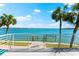 Breathtaking waterfront view featuring a private dock, calm waters, and swaying palm trees at 520 Belle Isle Ave, Belleair Beach, FL 33786