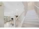 Bright foyer featuring a white staircase and a view of the open-concept living area, creating an inviting and spacious atmosphere at 6867 Citrus Creek Ln, Tampa, FL 33625