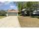 Charming single-story home featuring a well-maintained lawn, mature tree, and a two-car garage at 7581 Palmer Glen Cir, Sarasota, FL 34240