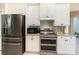 Kitchen features stainless steel appliances, granite countertops, and white cabinetry at 7581 Palmer Glen Cir, Sarasota, FL 34240
