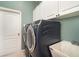 Laundry room with front load washer and dryer and white cabinets at 7581 Palmer Glen Cir, Sarasota, FL 34240