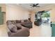 Open-concept living room with tile flooring, comfortable seating, and sliding glass doors to the outdoor area at 7581 Palmer Glen Cir, Sarasota, FL 34240
