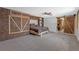 Open bedroom with wood paneling, shelving, barn door and ceiling fan for a rustic and inviting feel at 9143 Dream Way, Largo, FL 33773