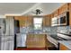 This kitchen features stainless steel appliances, wooden cabinets and granite countertops at 9301 Pegasus Ave, Port Richey, FL 34668