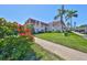 Exterior of a two-story building with lush green lawns and vibrant pink flowers at 10038 62Nd N Ter # 21, St Petersburg, FL 33708