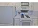 Bright kitchen with white cabinets and appliances featuring a sleek black tiled backsplash at 10038 62Nd N Ter # 21, St Petersburg, FL 33708